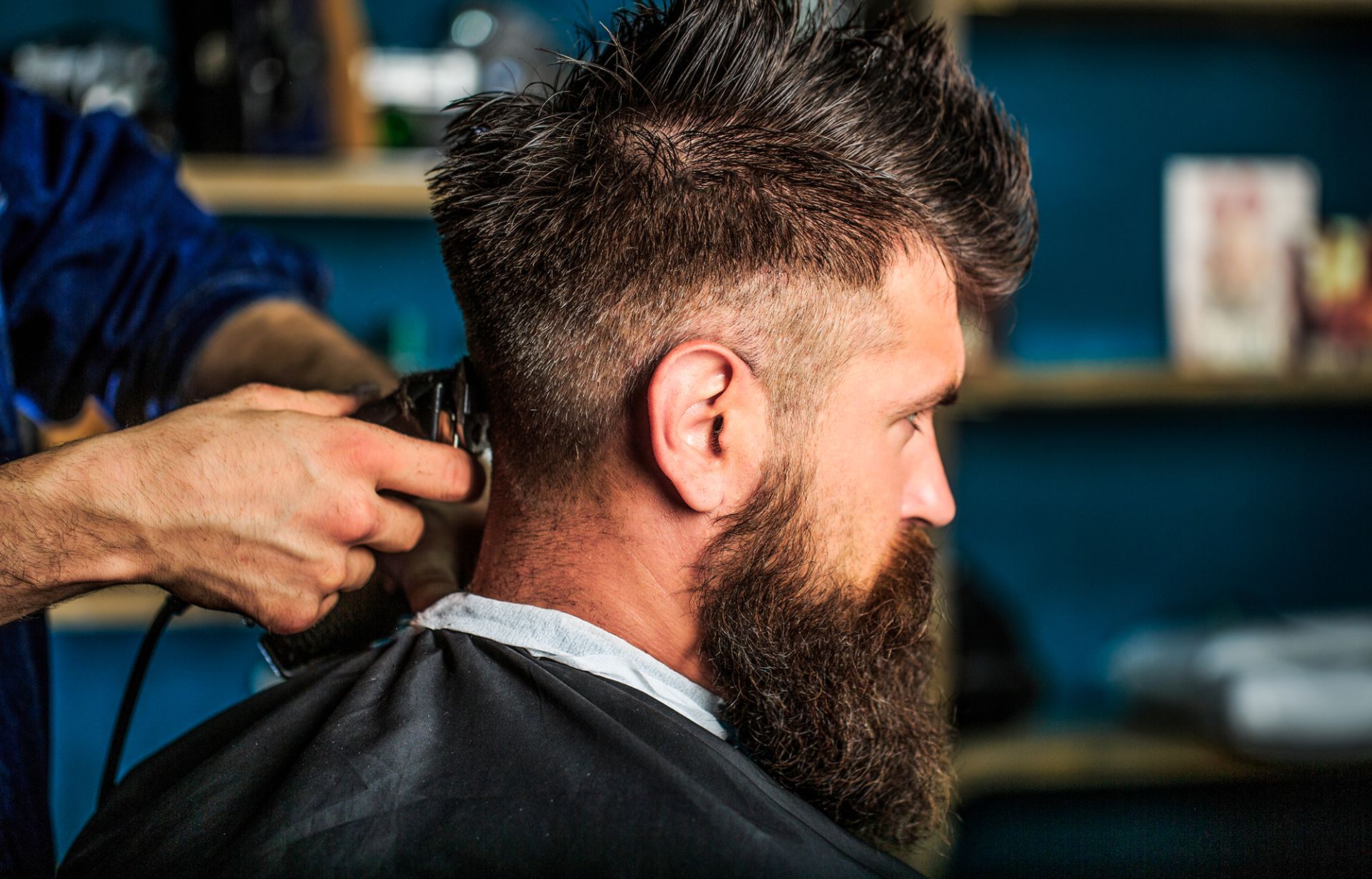 man-visiting-hairstylist-barbershop-barber-works-with-hair-clipper